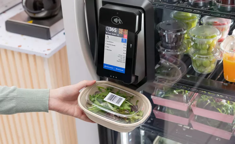 Person scanning salad with payment terminal on vending machine