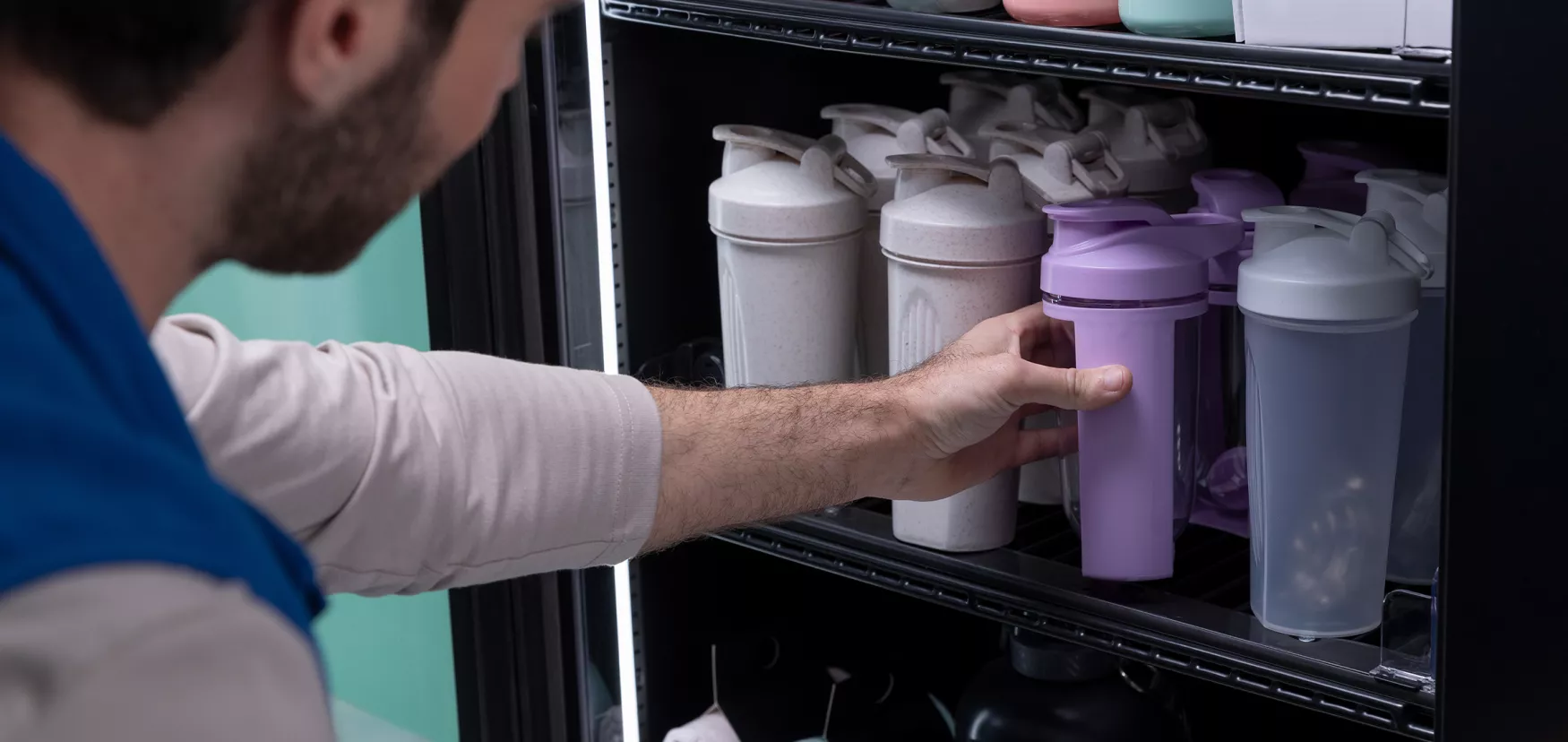 Man selecting water bottle from vending machine